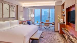 een hotelkamer met een groot bed en een bureau bij InterContinental Guangzhou Exhibition Center, an IHG Hotel - Free shuttle between hotel and Exhibition Center during Canton Fair & Exhibitor registration Counter in Guangzhou