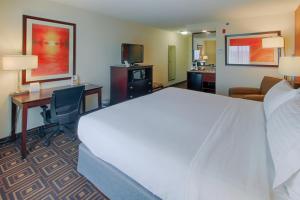 a hotel room with a large bed and a desk at Holiday Inn Knoxville West - Cedar Bluff, an IHG Hotel in Knoxville