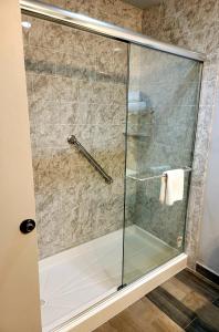 a shower with a glass door in a bathroom at Blue Bay Inn and Suites in South Padre Island