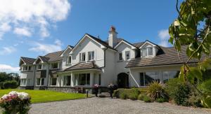 uma grande casa branca com um telhado em Loch Lein Country House em Killarney