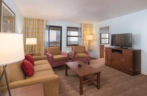 een woonkamer met een bank en stoelen en een flatscreen-tv bij Club Wyndham Skyline Tower in Atlantic City