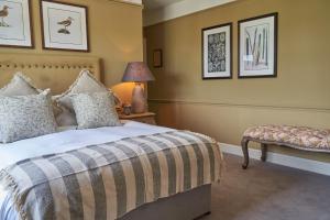 una camera con letto, tavolo e lampada di The Fleet Inn a Tewkesbury