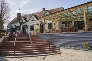 un edificio con scale di fronte a un edificio di The Fleet Inn a Tewkesbury