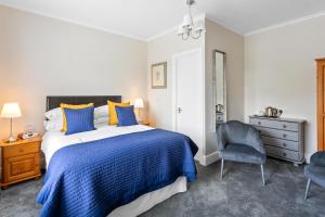 1 dormitorio con 1 cama y 1 silla en Stover Lodge, en Torquay