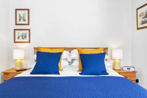 1 cama con almohadas azules y amarillas y 2 lámparas en Stover Lodge, en Torquay