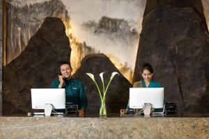 twee mensen zitten aan een bureau met hun laptops bij The Manohara Hotel Yogyakarta in Yogyakarta