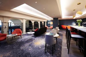 a hotel lobby with tables and chairs and a bar at The Dilly in London