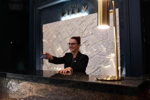 a man sitting at a counter holding a remote control at The Dilly in London