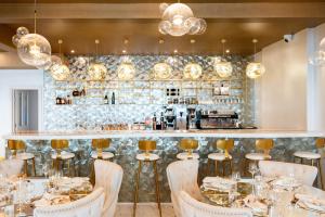 a restaurant with a bar with tables and chairs at OYO Newquay Beach Hotel in Newquay