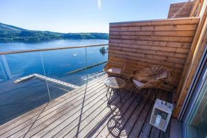 una terrazza in legno con vista su una cassa d'acqua di Mjøssuite with lovely view a Ringsaker