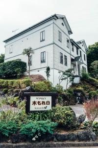 a large white building with a sign in front of it at ペンション木もれ日 in Ito