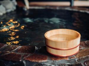 a wooden cup sitting in a pool of water at ペンション木もれ日 in Ito