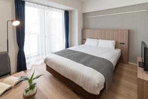 um quarto com uma cama grande e uma televisão em BON Tokyo Asakusa em Tóquio