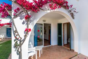 een huis met roze bloemen aan de voorkant en een boog bij Apartamentos Vistapicas in Cala en Blanes