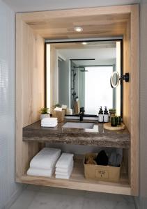 a bathroom with a sink and a mirror and towels at 1 Hotel Toronto in Toronto