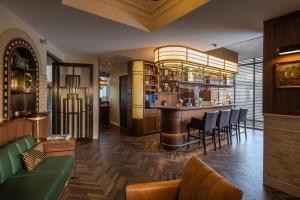 een bar in een restaurant met een groene bank en stoelen bij Grand Hotel Valies in Roermond