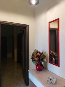 a vase of flowers on a counter with a mirror at Arte Mia B&B in Reggio di Calabria