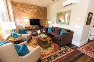 a living room with a couch and a brick wall at The Windsor - Asheville in Asheville