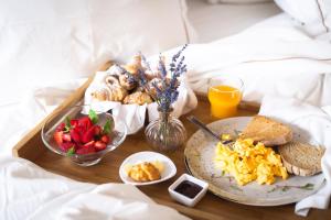 - un plateau de petit-déjeuner avec des aliments pour le petit-déjeuner sur un lit dans l'établissement Corpo Santo Lisbon Historical Hotel, à Lisbonne