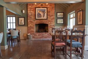 un soggiorno con camino, tavolo e sedie di The Fleet Inn a Tewkesbury