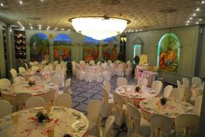 a banquet hall with white tables and white chairs at Hotel La Bussola in Cittiglio