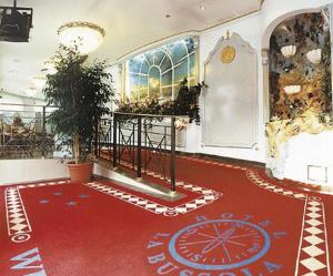 a room with a red carpet and a large window at Hotel La Bussola in Cittiglio