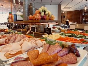 un buffet lleno de diferentes tipos de carnes y hortalizas en Hotell Arkad, en Västerås