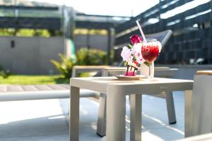 - une table blanche avec une boisson et des fleurs dans l'établissement Villa Aurora, à Baška