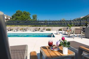 une terrasse avec une table et une piscine dans l'établissement Villa Aurora, à Baška