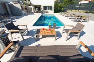 - une piscine avec des chaises et une table à côté de la piscine dans l'établissement Villa Aurora, à Baška