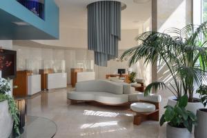 a living room with a white couch and some plants at Melia Lisboa Oriente Hotel in Lisbon