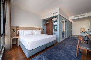 a bedroom with a white bed and a blue rug at Melia Lisboa Oriente Hotel in Lisbon