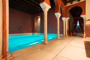 una piscina en una casa con columnas en Hospedería Baños Arabes de Córdoba Dos, en Córdoba