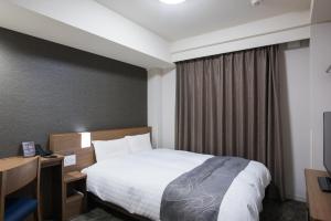 pokój hotelowy z łóżkiem i oknem w obiekcie Dormy Inn EXPRESS Sendai Seaside w mieście Sendai