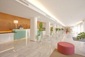 un hall avec des plantes en pot dans un bâtiment dans l'établissement Grupotel Molins, à Cala Sant Vicenç