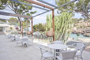 une terrasse avec des tables et des chaises ainsi qu'une piscine dans l'établissement Grupotel Molins, à Cala Sant Vicenç