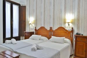 1 dormitorio con 2 camas y toallas blancas. en Hotel Marisa, en Córdoba