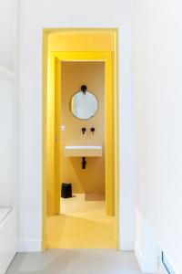 a yellow bathroom with a sink and a mirror at Malalbergo in Reggio di Calabria