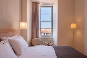 A bed or beds in a room at Memoria Lisboa FLH Hotels