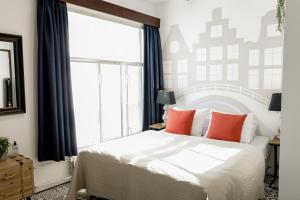 a bedroom with a bed and a large window at Aris Amsterdam in Amsterdam