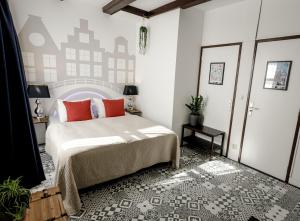 a bedroom with a bed with red pillows on it at Aris Amsterdam in Amsterdam