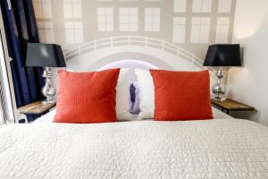 a bedroom with a white bed with two red pillows at Aris Amsterdam in Amsterdam