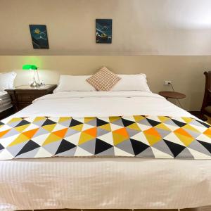 a bed with a colorful blanket on top of it at 墾丁聚點旅棧 2Ps Hotel in Kenting