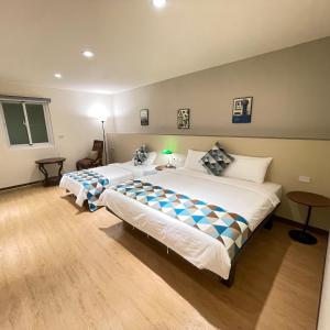 a bedroom with two beds in a room at 墾丁聚點旅棧 2Ps Hotel in Kenting