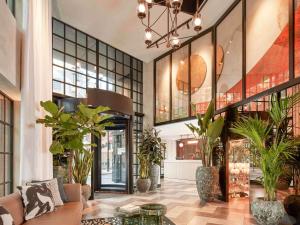 a lobby with potted plants in a building at Virgin Hotels London - Shoreditch in London