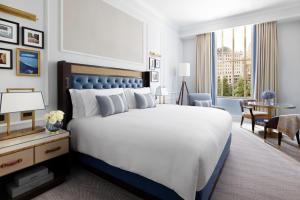 a bedroom with a king sized bed and a desk at The Langham, Boston in Boston