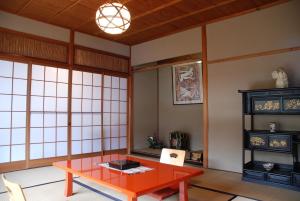 a room with a red table and some windows at Yadoya Manjiro in Kyoto