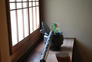 a baseball bat and a potted plant next to a window at Yadoya Manjiro in Kyoto