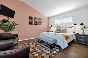 a bedroom with a bed and a tv and a chair at Red Rock Inn Cottages in Springdale