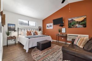 a bedroom with a bed and a couch at Red Rock Inn Cottages in Springdale